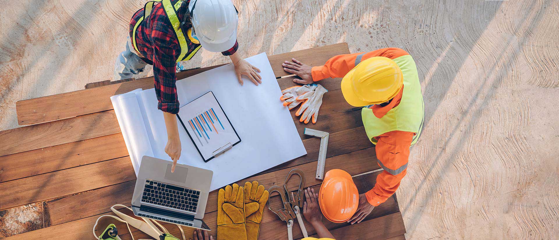 Ingénieurs opusbati à Toulouse planifiant un chantier sur plan et ordinateur avec équipements de sécurité