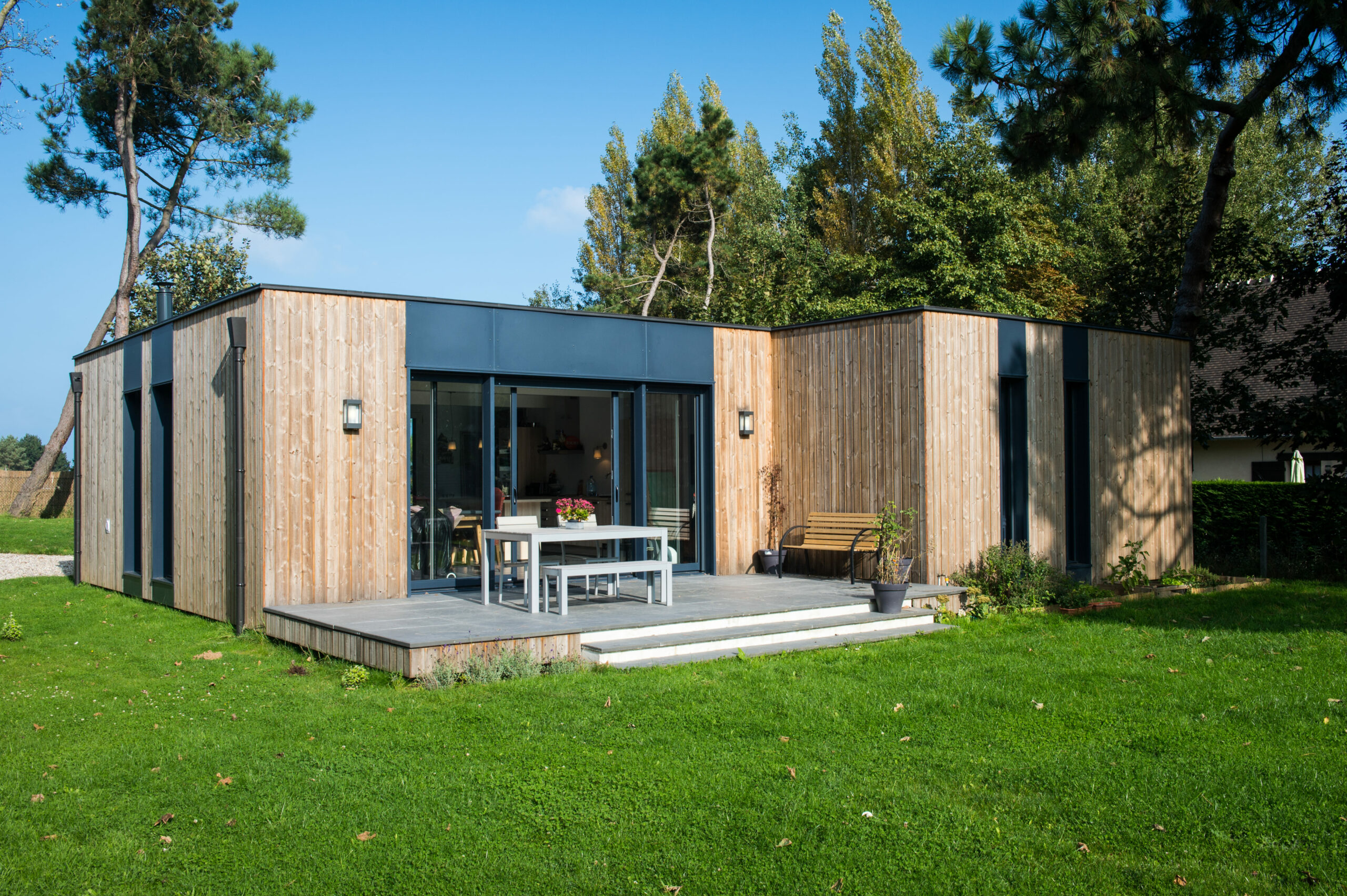 Maison contemporaine en bois avec terrasse et jardin verdoyant par opusbati à Toulouse