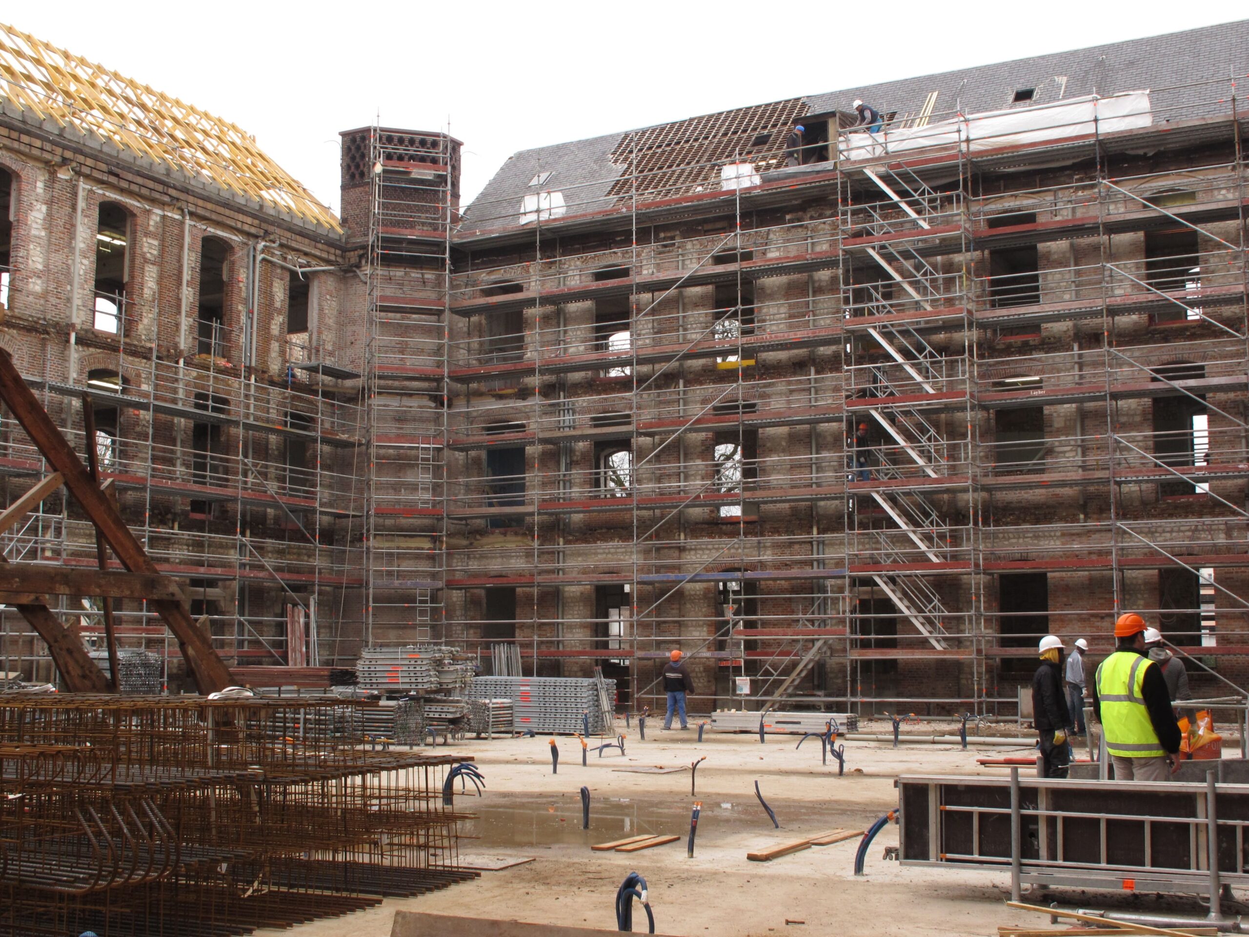Chantier de rénovation d’un bâtiment en briques par opusbati à Toulouse avec échafaudages et ouvriers