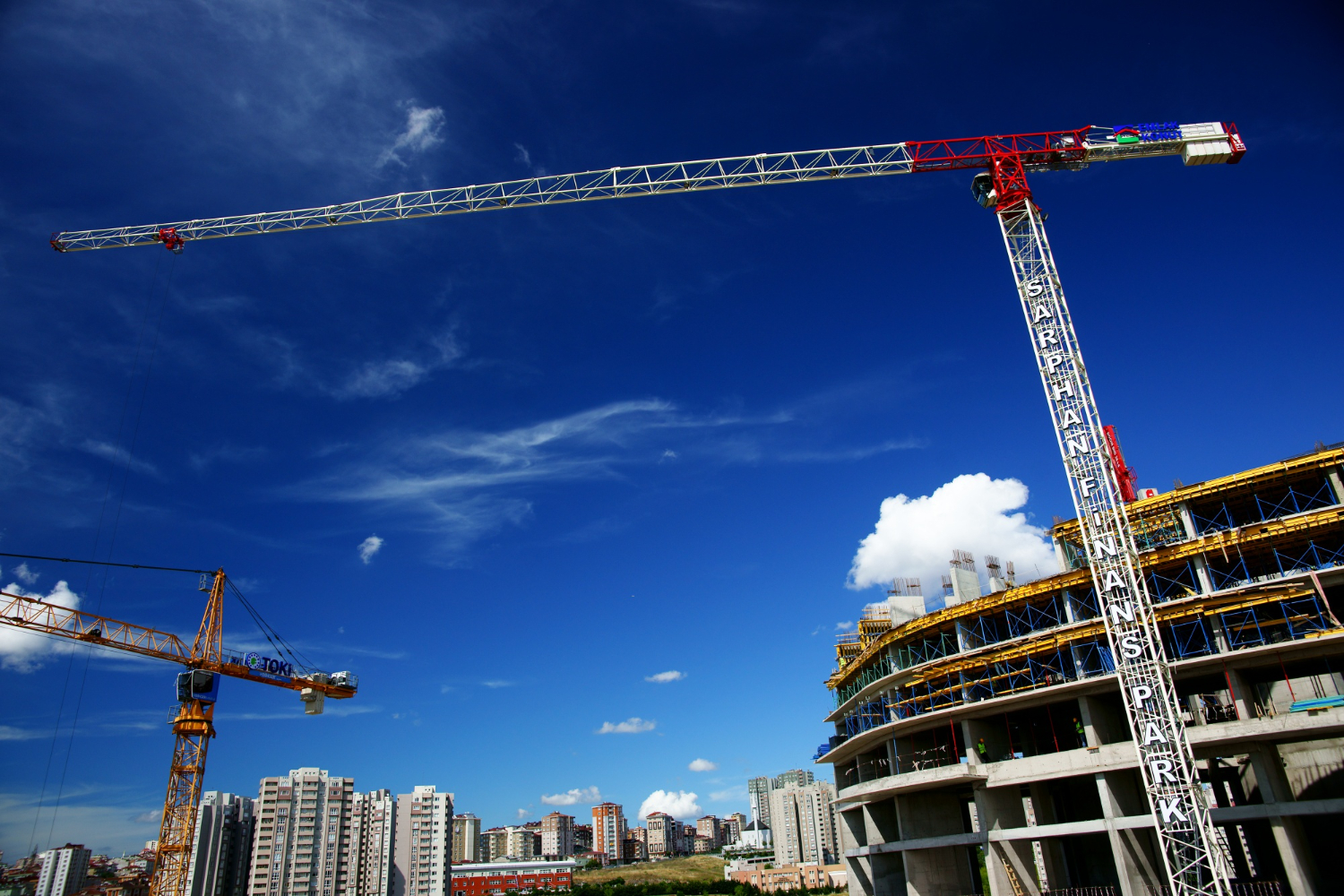 Chantier urbain opusbati à Toulouse avec grues et immeuble moderne en construction sous ciel bleu