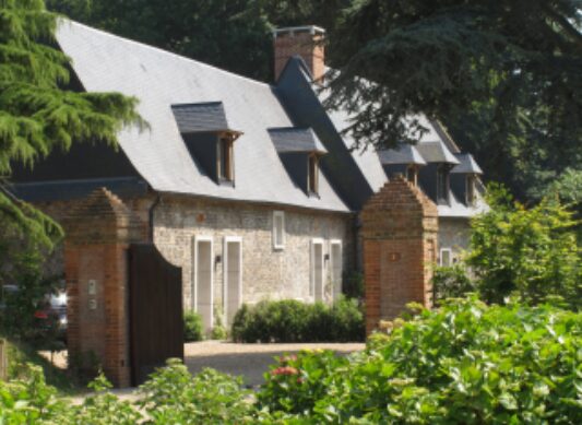 Maison en pierre rénovée par opusbati, jardin verdoyant et toit en ardoise, style campagne près de Toulouse