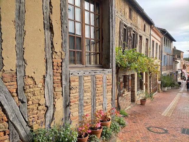 Façades anciennes à colombages restaurées par opusbati dans une rue pavée pittoresque à Toulouse